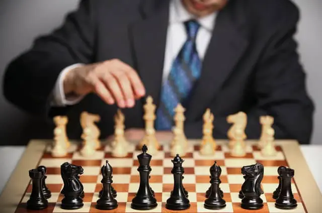 Why do chess players touch their pieces before a game?